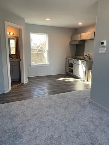 an empty room with windows and fireplace