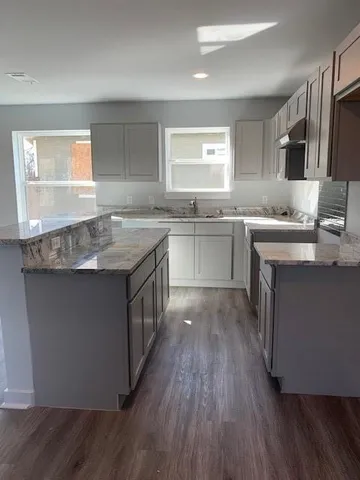 a kitchen with center island and wooden floors