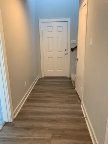 a view of a hallway with wooden floor and entryway