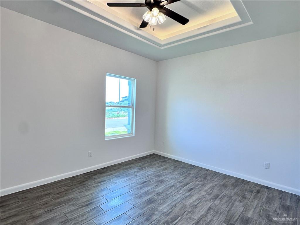 1100 Azalea Street Mission, TX 78573 - Photo 19 of 24 an empty room with wooden floor and windows