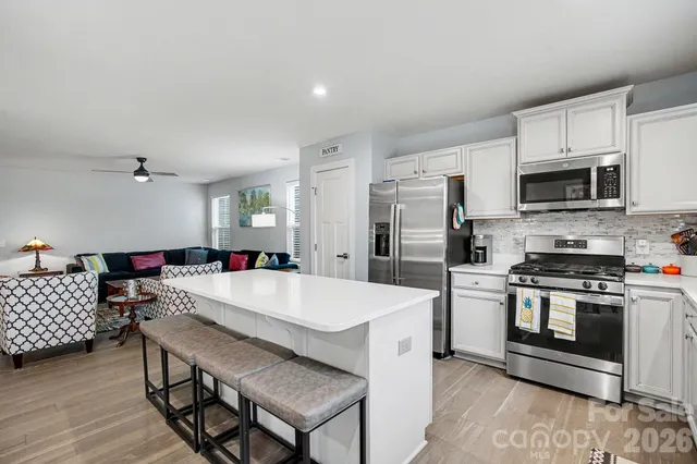 a kitchen with a sink a stove a refrigerator and white cabinets