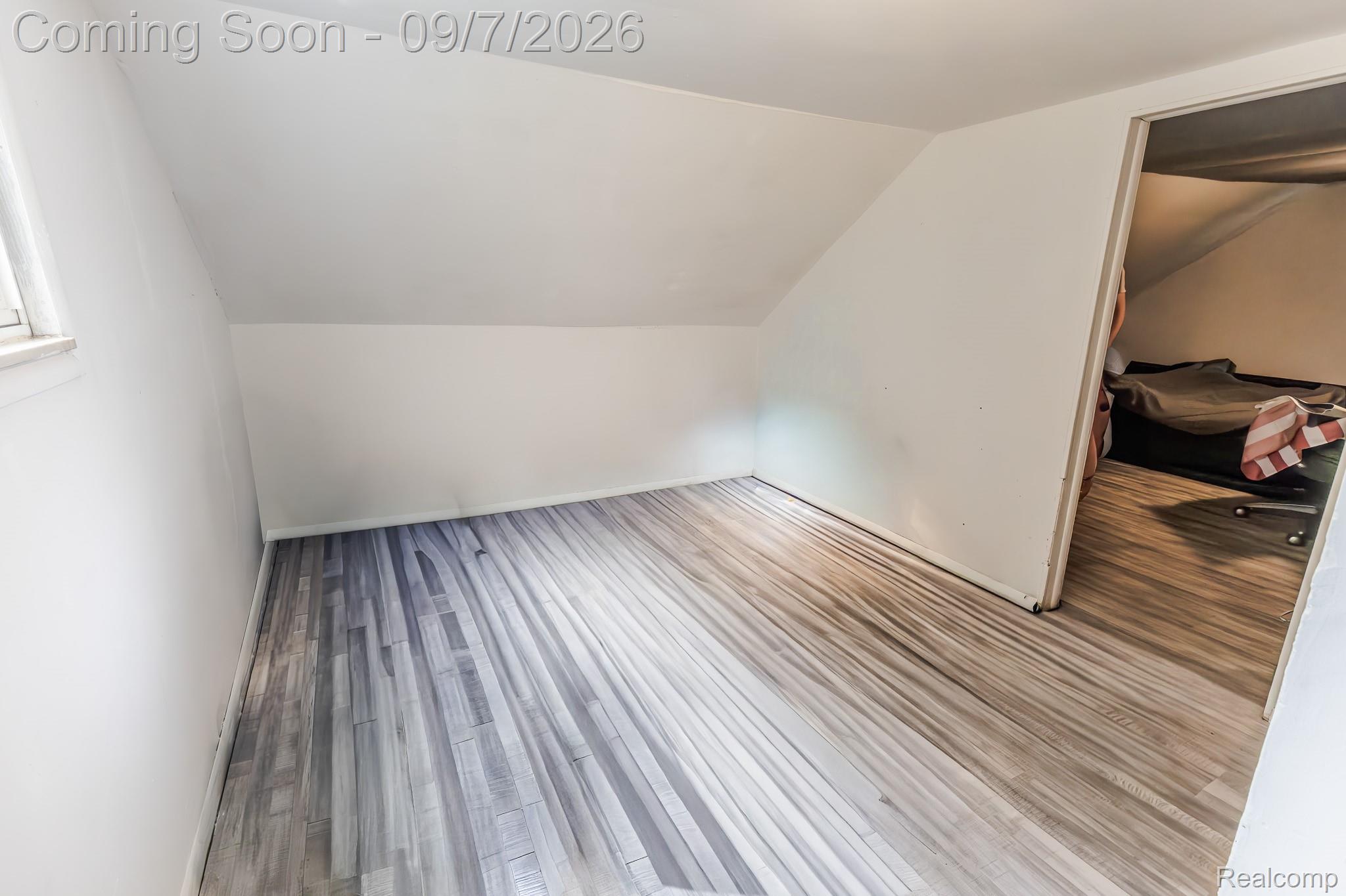8368 Vassar Road Millington, MI 48746 - Photo 16 of 32 Wood-finish flooring with a sloped ceiling and window