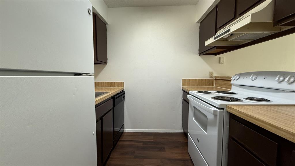410 Bryan Street, Unit 10 Denton, TX 76201 - Photo 4 of 10 a kitchen with a stove and a refrigerator