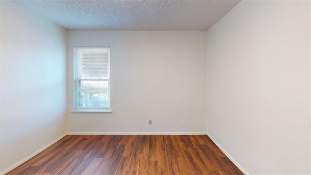 410 Bryan Street, Unit 10 Denton, TX 76201 - Photo 9 of 10 an empty room with wooden floor and windows