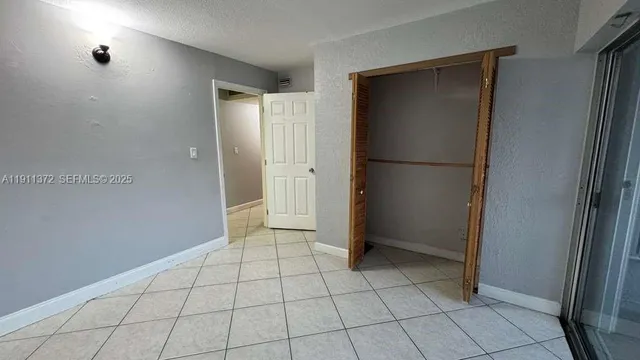 a view of a hallway with wooden floor and cabinet
