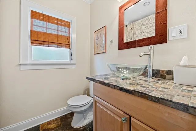 a bathroom with a granite countertop toilet sink and mirror