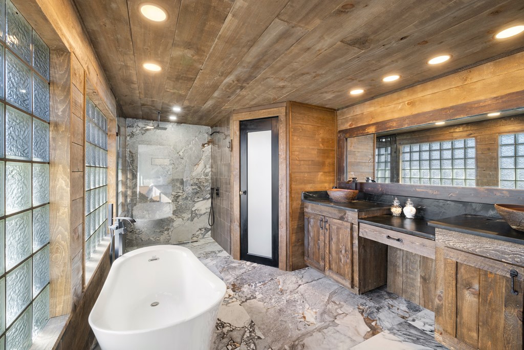 3800 Cutcane Road Mineral Bluff, GA 30559 - Photo 29 of 68 a bathroom with a granite countertop sink a bathtub and shower