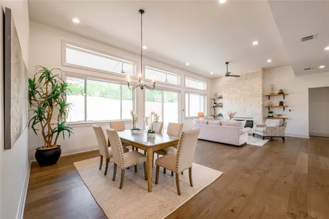 a view of a dining room and livingroom with furniture wooden floor a chandelier