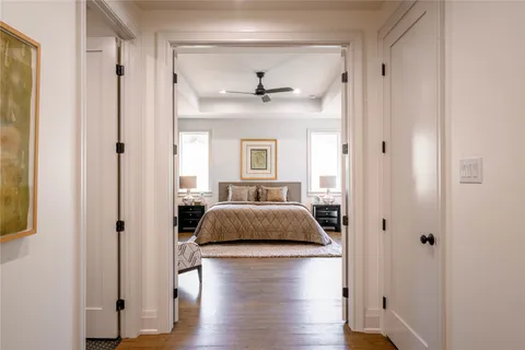 a living room with a bed and wooden floor