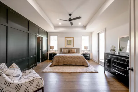 a spacious bedroom with a bed and wooden floor