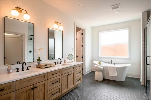 a spacious bathroom with a double vanity sink mirror and a bathtub