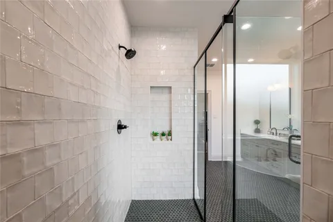 a bathroom with a glass shower door and a sink