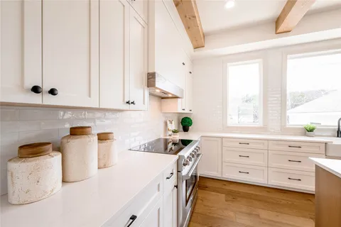 a kitchen with cabinets appliances a sink and a window