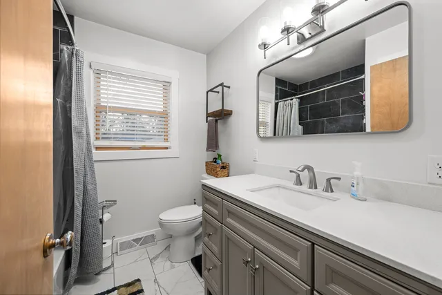 a bathroom with a sink a toilet and mirror