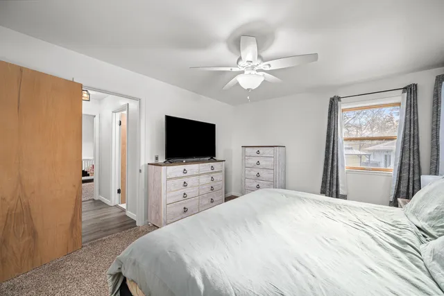 a bedroom with a bed and a flat tv screen on dresser