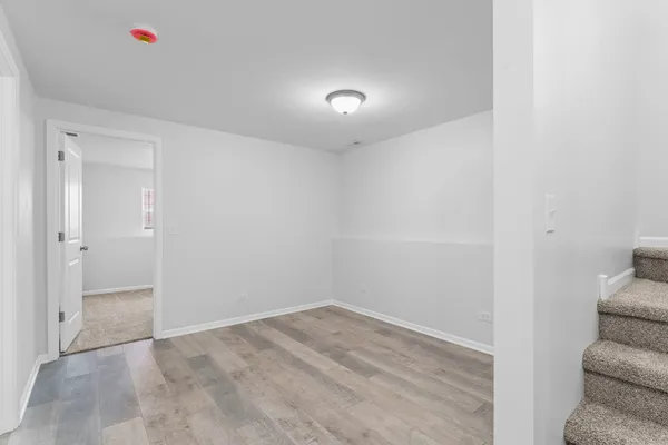 a view of a livingroom with wooden floor and a hallway