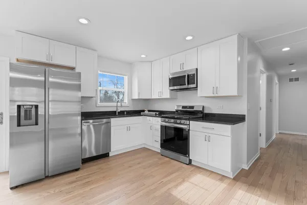 a kitchen with stainless steel appliances granite countertop a stove a sink and a refrigerator