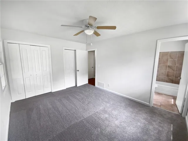 a view of empty room with wooden floor and ceiling fan