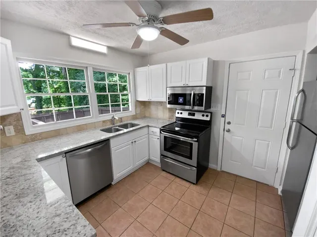 a kitchen with a stove a sink and a microwave