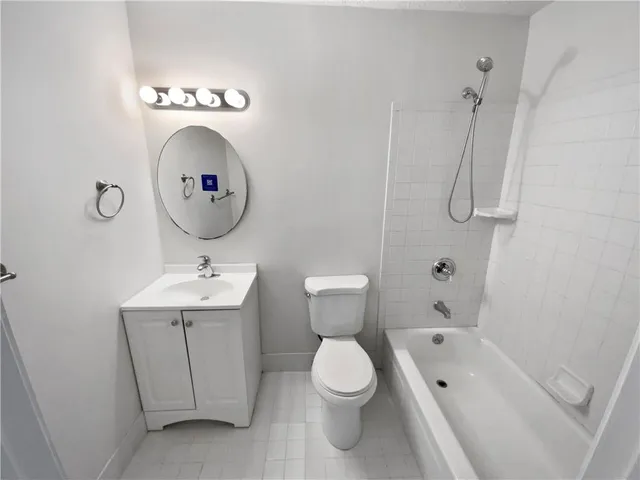 a bathroom with a toilet sink vanity tub and shower