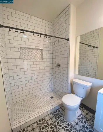 a bathroom with a toilet a window and shower