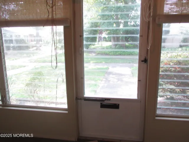 a view of empty room with wooden floor and front door