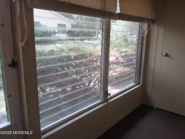 a view of empty room with wooden floor and windows