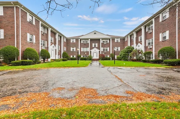a view of a big building with a big yard and plants