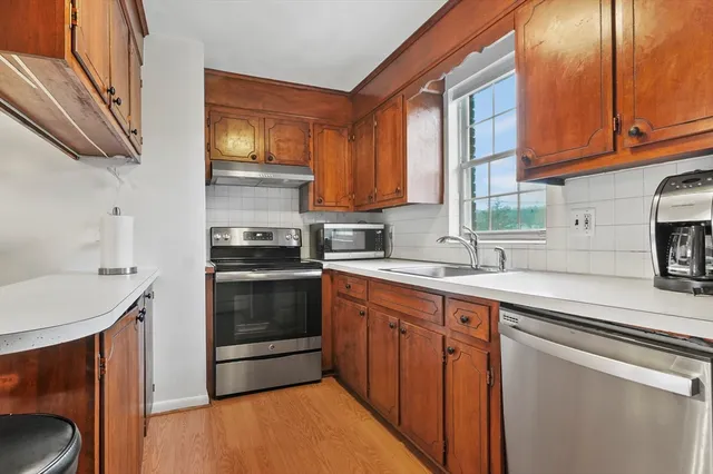 a kitchen with stainless steel appliances a stove sink and cabinets
