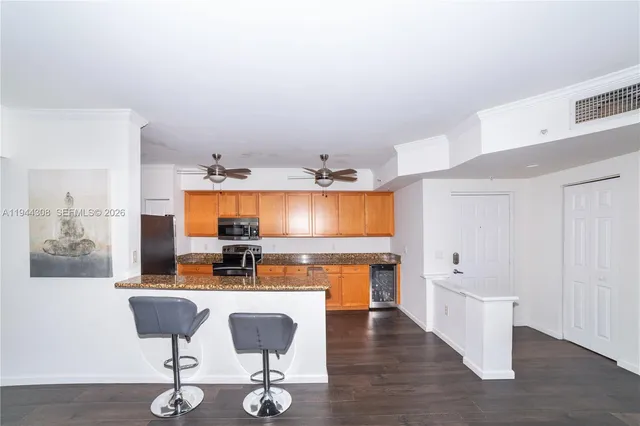 a kitchen with stainless steel appliances kitchen island granite countertop a stove a sink and a microwave