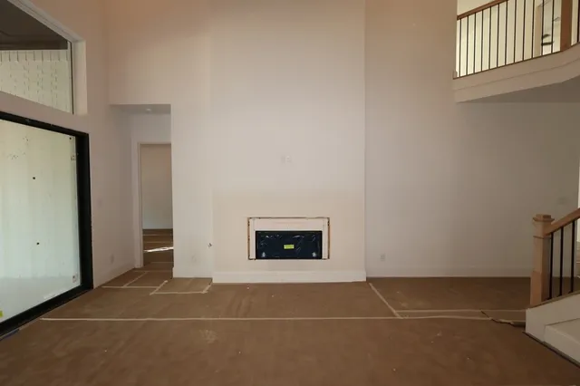 a view of an empty room with window and fire place