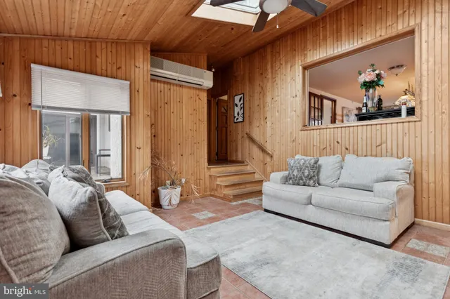 a living room with furniture and a painting on the wall