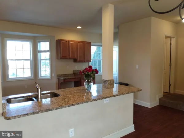 a kitchen with kitchen island granite countertop a sink and a granite counter top