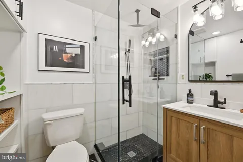 a bathroom with a sink vanity granite shower and a mirror
