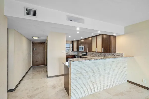 a view of a kitchen with kitchen island a sink stainless steel appliances and cabinets