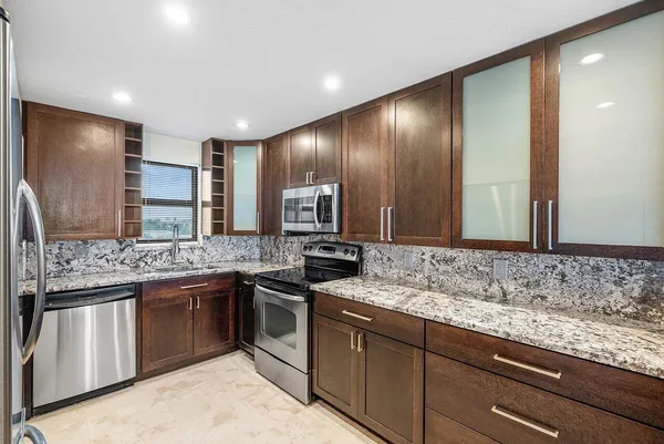 a kitchen with stainless steel appliances granite countertop a sink and stove top oven