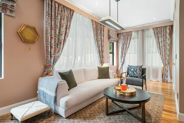 a living room with fireplace furniture and a large window