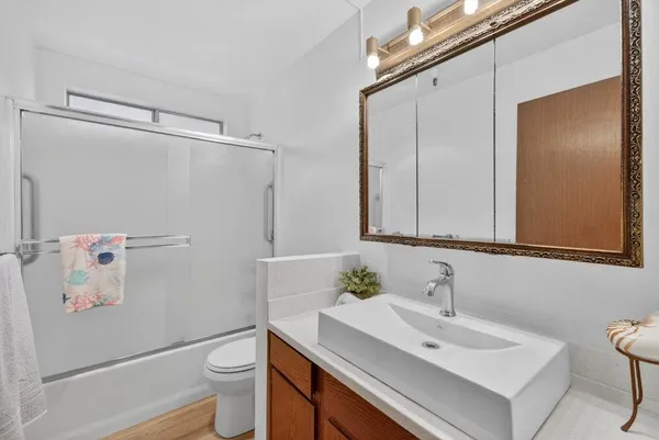 a bathroom with a sink vanity mirror and toilet