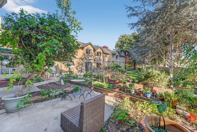 a view of a backyard with table and chairs and potted plants