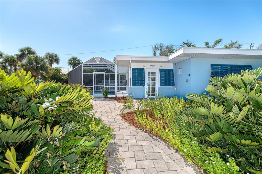 2835 North Beach Road, Unit A Englewood, FL 34223 - Photo 9 of 58 a front view of a house with a yard table and chairs