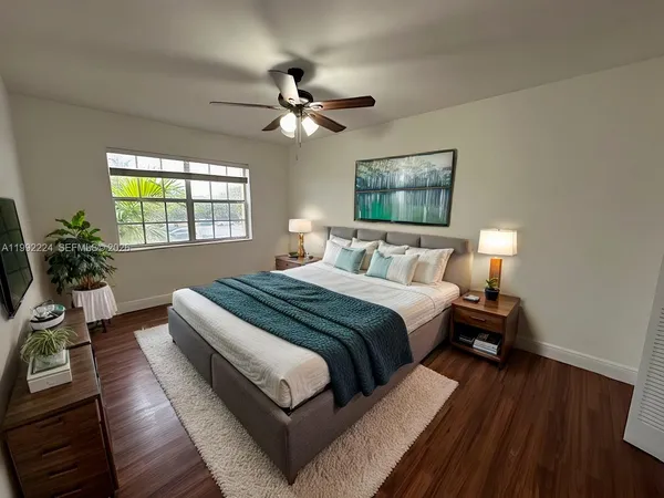 a bedroom with a bed lamp on table and a window