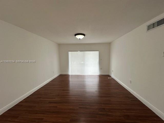 5400 Southwest 77th Court, Unit 2R Miami, FL 33155 - Photo 8 of 16 a view of an empty room with wooden floor and a window