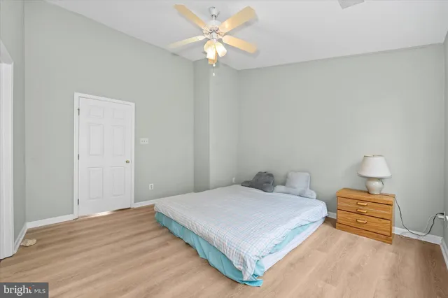 a bedroom with a bed and a chandelier fan