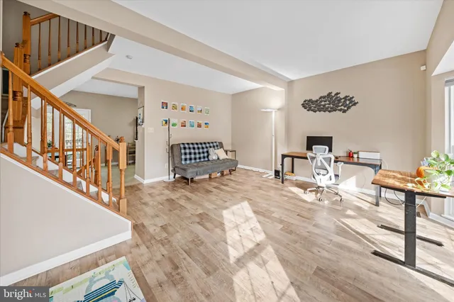 a view of a livingroom with wooden floor and staircase
