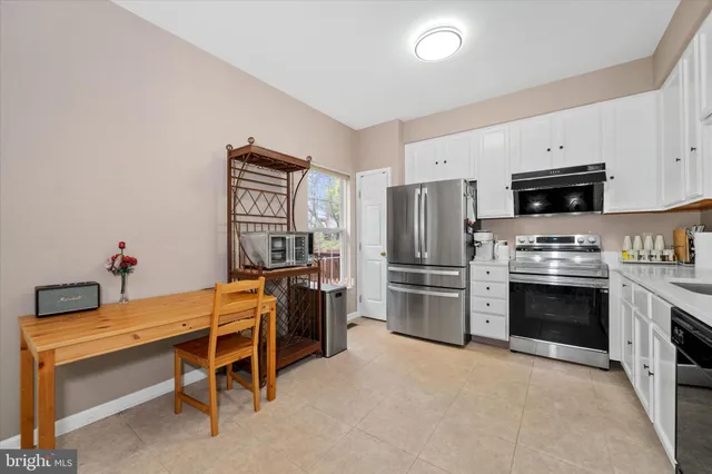a kitchen with cabinets stainless steel appliances and a counter space