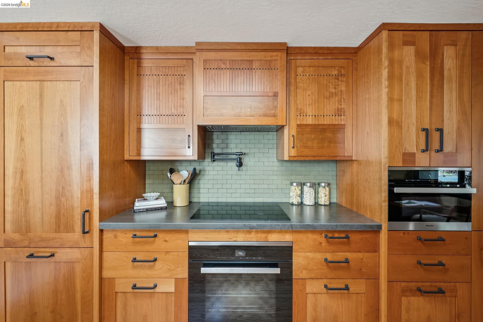 576 Vistamont Avenue Berkeley, CA 94708 - Photo 11 of 33 Kitchen featuring extensive wood cabinetry, dark countertops, a tile backsplash, built-in oven, and a cooktop