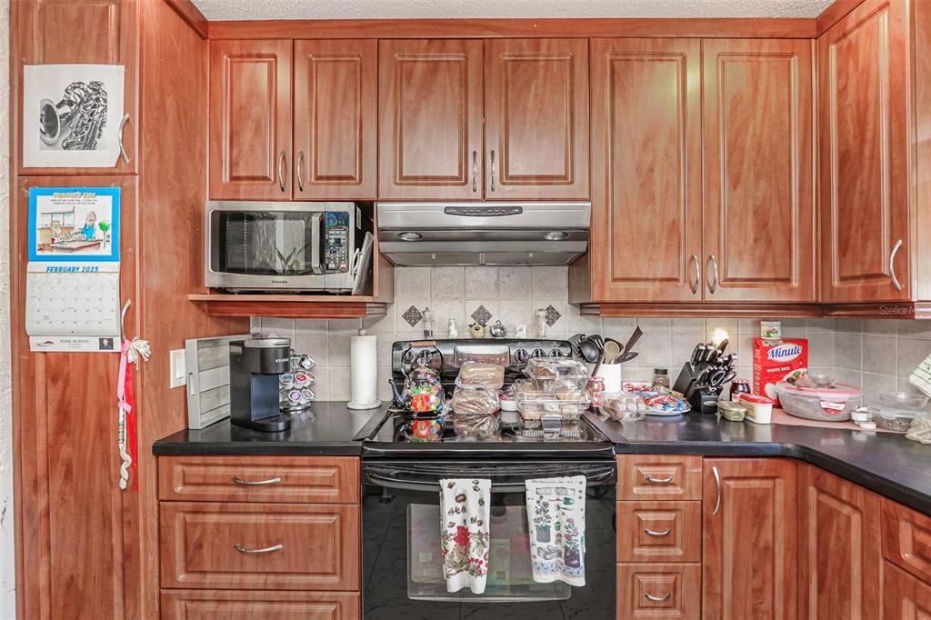 10039 88th Street Seminole, FL 33777 - Photo 14 of 44 a kitchen with stainless steel appliances granite countertop a stove and cabinets