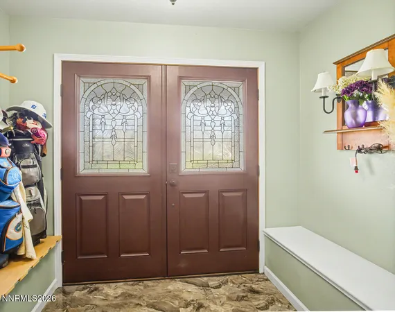 a living room with a table chairs and a ceiling fan