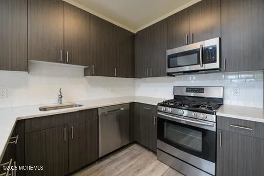 a kitchen with stainless steel appliances a stove a microwave and sink