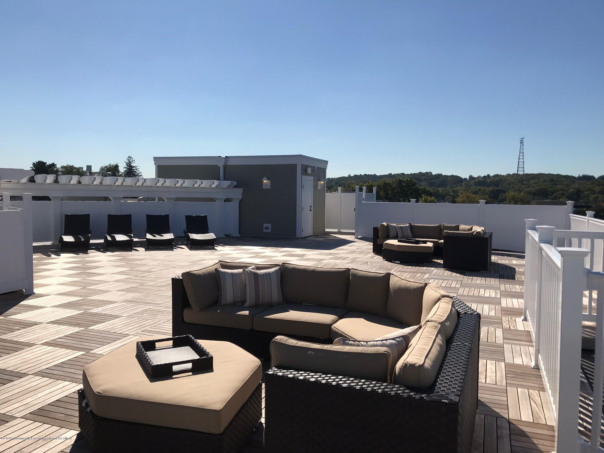 2 Henessey Boulevard, Unit 304 Atlantic Highlands, NJ 07716 - Photo 16 of 19 a balcony with furniture and a fireplace